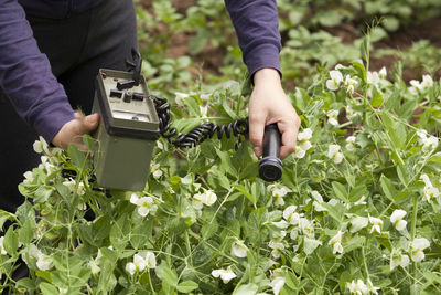 Midsection of woman using agricultural machinery on field