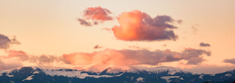 Panoramic view of snowcapped mountains against sky during sunset