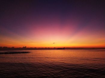 Scenic view of sea against romantic sky at sunset