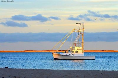 Sailboat in sea at sunset