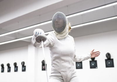 Woman in fencing outfit at gym