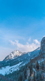 Scenic view of snow mountains against blue sky