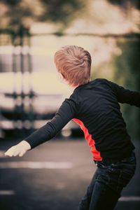 Rear view of boy standing in lake