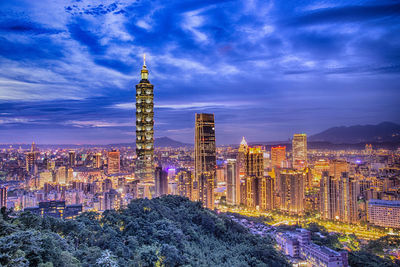 Illuminated buildings against sky at night