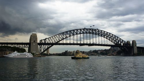 Bridge over river against cloudy sky