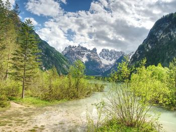 Scenic view of river amidst mountains against sky