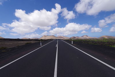 Road leading towards mountain against sky