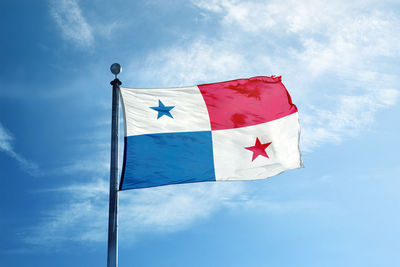 Low angle view of flag against blue sky