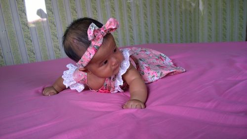 Full length of cute girl lying on bed