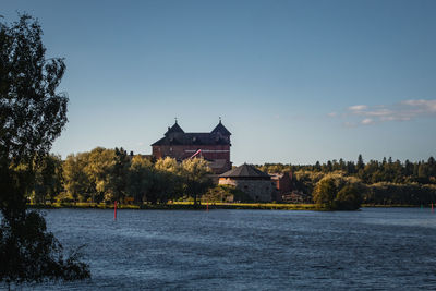 Scenic view of river by buildings against sky