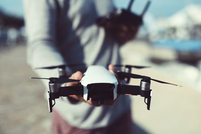 Midsection of man holding drone