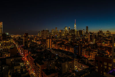 Illuminated cityscape against sky at night