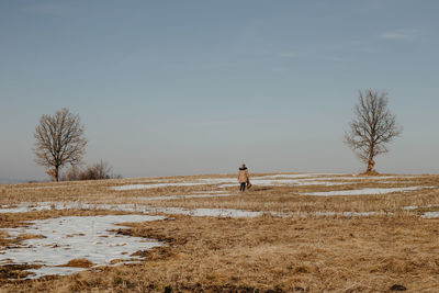 Woman on field against sky during winter