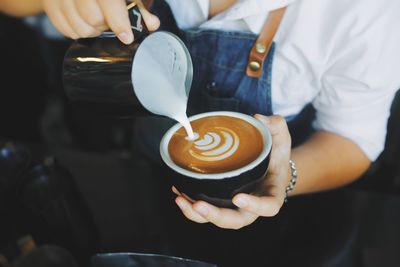 Midsection of man holding coffee