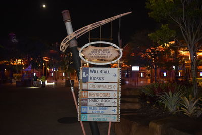 Information sign on street in city at night