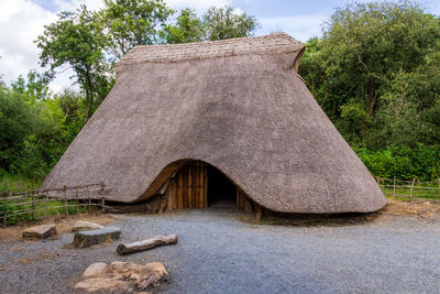 Tilt image of stone wall by trees against sky