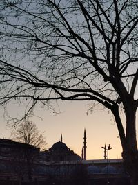 Silhouette of trees and building against sky during sunset