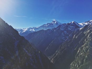 Scenic view of snowcapped mountains against blue sky