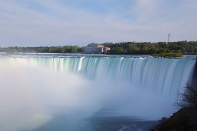 Scenic view of waterfall against sky