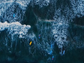 High angle view of people swimming and surfing in the sea