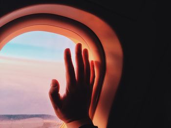 Cropped image of hand on airplane window