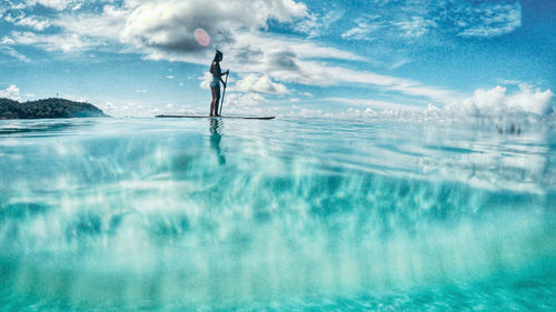 Man surfing in sea against sky