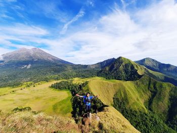 Rear view of people on mountain against sky