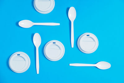 Set of plastic cutlery neatly arranged on a blue background