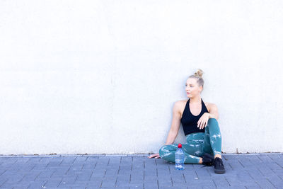 Portrait of young woman sitting on street