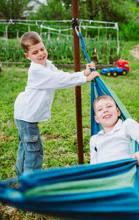 Happy children play and ride on a hammock. the kids have fun rolling in a hammock. summer holidays 