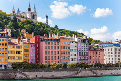 Buildings in city against cloudy sky