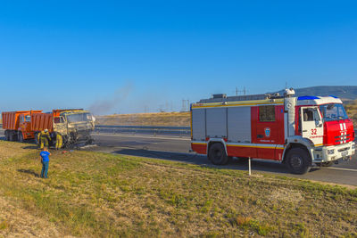 Truck on field against clear blue sky