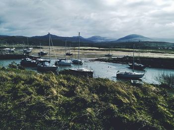 Boats in sea against cloudy sky