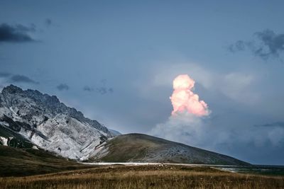 Scenic view of mountains against cloudy sky