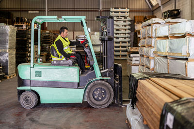 Worker operating forklift at warehouse