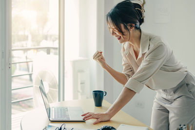 Cheerful woman talking on video call by table