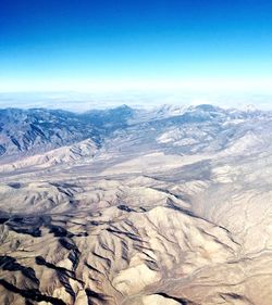 Scenic view of dramatic landscape against blue sky
