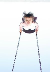 Portrait of smiling girl on swing at playground