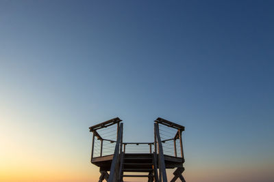 Structure on beach against sky during sunset