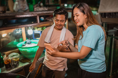 Portrait of smiling friends toasting drinks at home