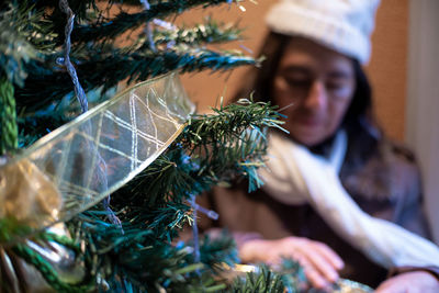 Old woman laces the christmas tree