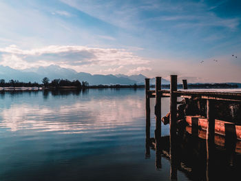 Pier over lake against sky during sunset