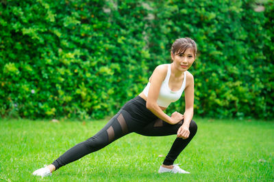 Full length of a young woman sitting on grass