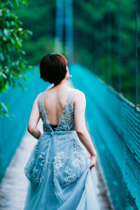 Rear view of woman standing against blurred background
