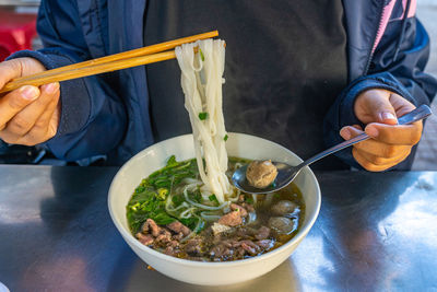 Midsection of person having food on table