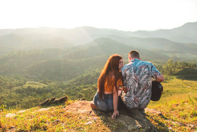 Rear view of couple on mountain against sky