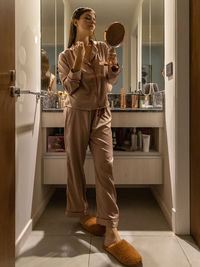 Full length of young man standing in kitchen