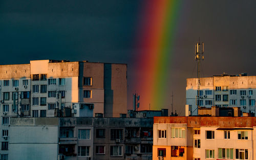 Residential buildings against rainbow in sky