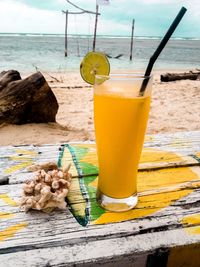 Close-up of drink on table at beach