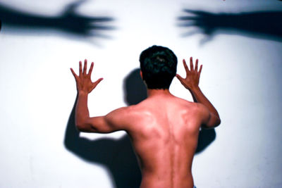 Rear view of shirtless man hand